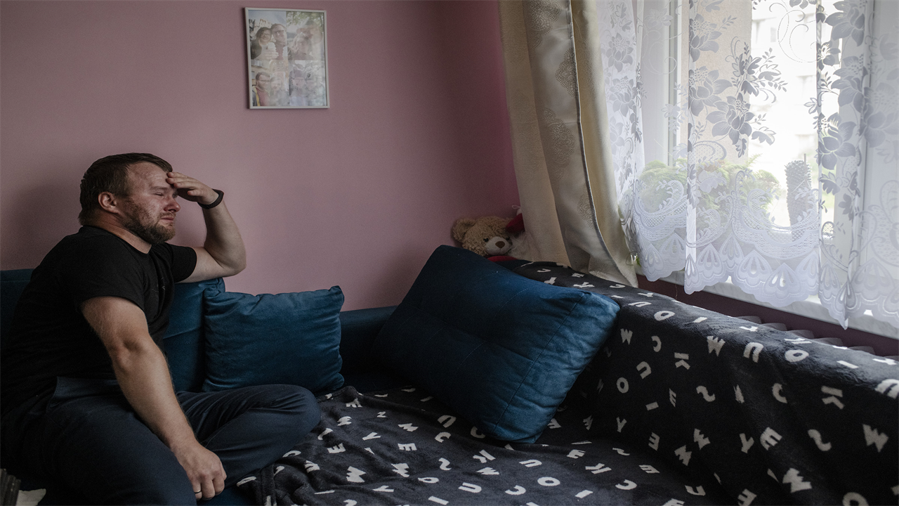 Krzysztof Sowinski sits on his couch in Dabrowa Gornicza, Poland, on July 31, where his late wife Marta rested in the days before she died. 